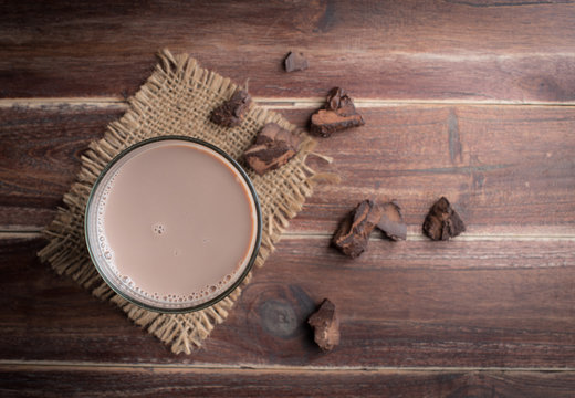 Glass of chocolate milk on wood table,top view