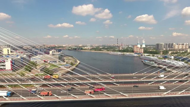 Day traffic is on the road at cable-stayed Bolshoy Obukhovsky Bridge. Timelapse part. Neva river, St. Petersburg, Russia
