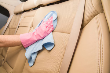 Car interior leather seats professionally chemical cleaning with cloth. Early spring cleaning or regular clean up.