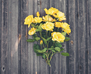 Bouquet of yellow garden roses on rustic weathered wooden background