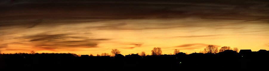 Panorama of sunrise and silhouettes of houses