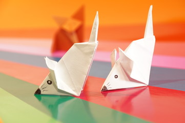 Paper origami fox and mouse are isolated on a colorful background