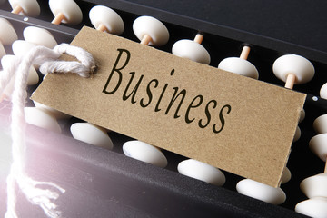 Abucas and paper tagging with business conceptual text. Lens flare added.