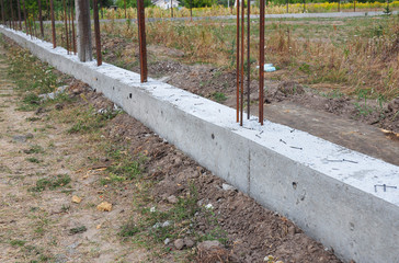 Building concrete foundation for metal fence.