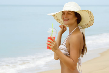 Woman in beach hat with a cocktail