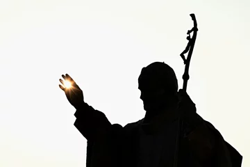Abwaschbare Fototapete Historisches Monument Silhouette of statue of pope John Paul The Second with afternoon sun in his palm, castle Nitra, Slovakia
