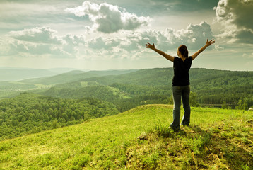 Woman spreading arms on a hilltop