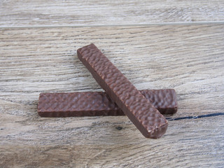 Two chocolate wafer biscuit on wood background