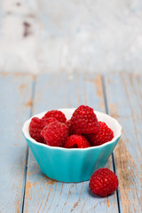 färska hallon i en turkos skål