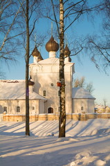 Fototapeta na wymiar Old white church in a snowy park