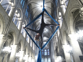 beautiful woman dancing with aerial silk in a cathedral interior