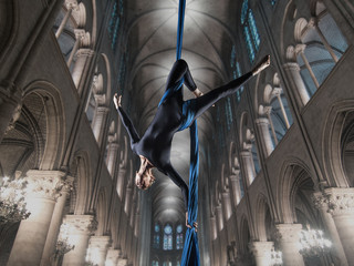 beautiful woman dancing with aerial silk in a cathedral interior