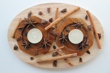 Aromatic cinnamon sticks and stars of anise with two candles.