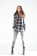 Full length of amazed attractive young woman standing and posing