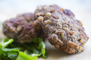 Bifschteksy and herbs on a wooden board.