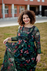 Happy curvy girl with curly hair in the street