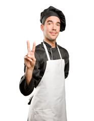 Confident young chef with a victory gesture