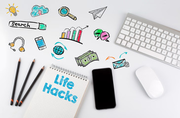 Life Hacks. Computer keyboard and mobile phone on a white table.
