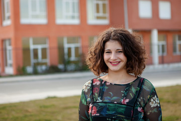 Fototapeta premium Happy curvy girl with curly hair in the street
