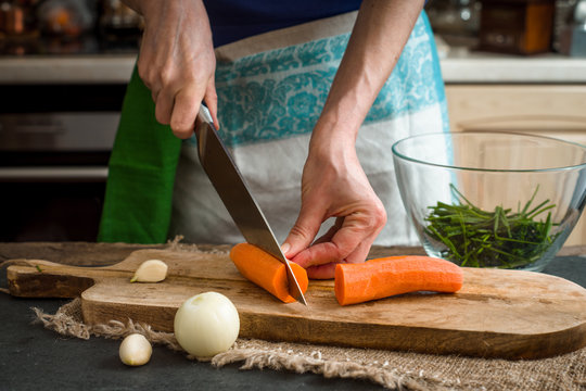 Cutting carrots on the wooden board horizontal