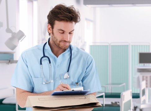 Doctor filling out patient record in hospital