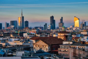 Fotobehang De skyline van Milaan met moderne wolkenkrabbers in de zakenwijk Porta Nuova in Milaan, Italië, bij zonsondergang. © Arcansél