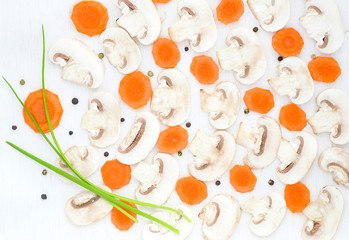 Sliced mushrooms, carrot, black pepper and green onion on white background