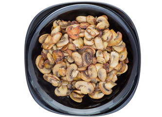 Fried mushrooms with green onion on a black plate isolated