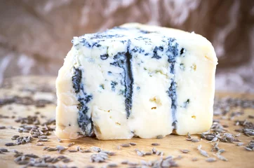 Gordijnen A piece of an amazing fresh blue cheese on a wood board. © Bastetamon