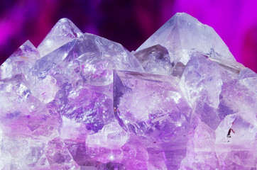 Beautiful natural amethyst crystals against purple background.