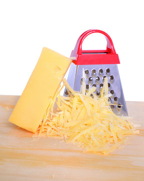 Bar cheese grater and grated cheese on cutting board isolated