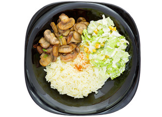 Fried mushrooms, rice and green onion on a black plate and vegetable salad on a white plate