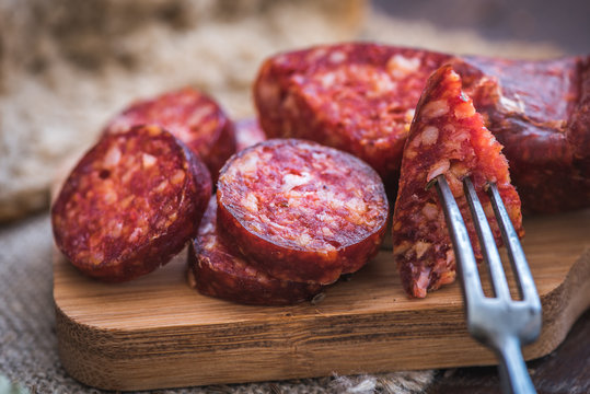 Sliced Raw Sausage on Wooden Cutting Board Ready to Eat