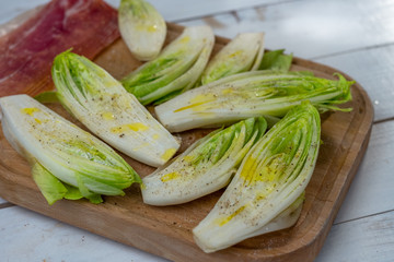 Fresh Chicory Salad on rustic wooden table.