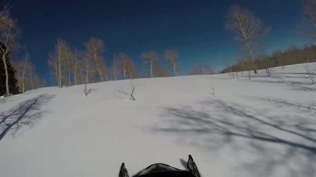 Snowmobile ride winter mountain snow forest POV. Snowmobile trail ride across high mountain meadow and forest at high speed high in central Utah in winter. Recreation and fun.
