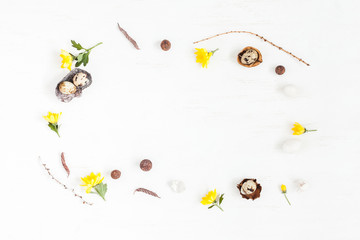 Easter frame made of quail eggs and yellow flowers. Easter concept. Flat lay, top view