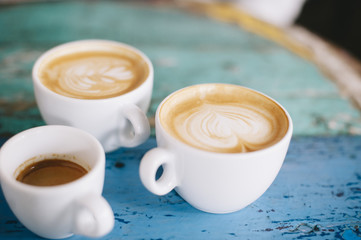 fresh tasty coffee on the coffee table. Two cappuccinos and one espresso