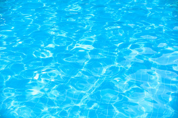 Fototapeta na wymiar Beautiful blue water surface with sun reflection in swimming pool