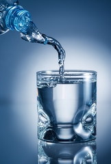 Water pouring from bottle into glass