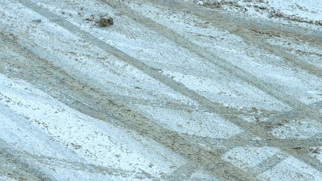 Timelapse of cars leaving tracks in the snow.
