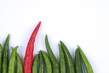 Red chili on green chillies on white background concept : different, win, better
