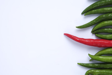Red chili on green chillies on white background concept : different, win, better