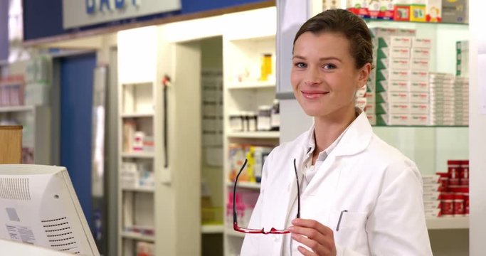 Pharmacist making prescription record on computer in pharmacy