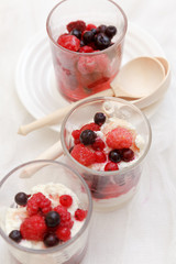 cottage cheese with berries in a glass on a white background