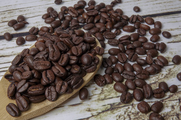 coffee beans and wooden spoon on old rusty background