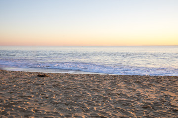 Romantic sunset light on the shore and wave on a winter evening