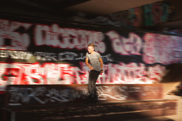 Young man rollerblading. Rollerblader near graffiti. Not afraid of speed.