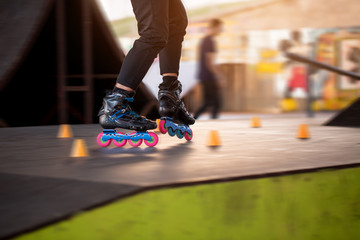 Legs of person rollerblading. Black skates with pink wheels. Be fast and agile.