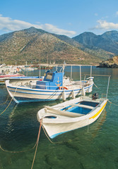 white fishing boats in small mountainous harbour