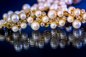 White pearl necklace isolated on black blue background.